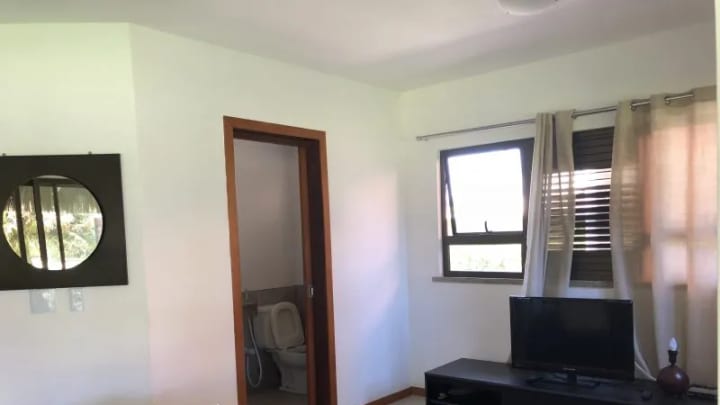 Sala com televisão e acesso aos quartos