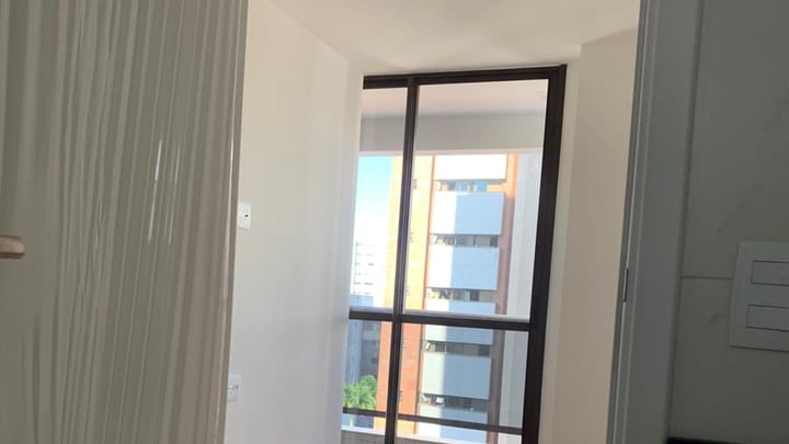 Ambiente iluminado do apartamento com porta para a varanda