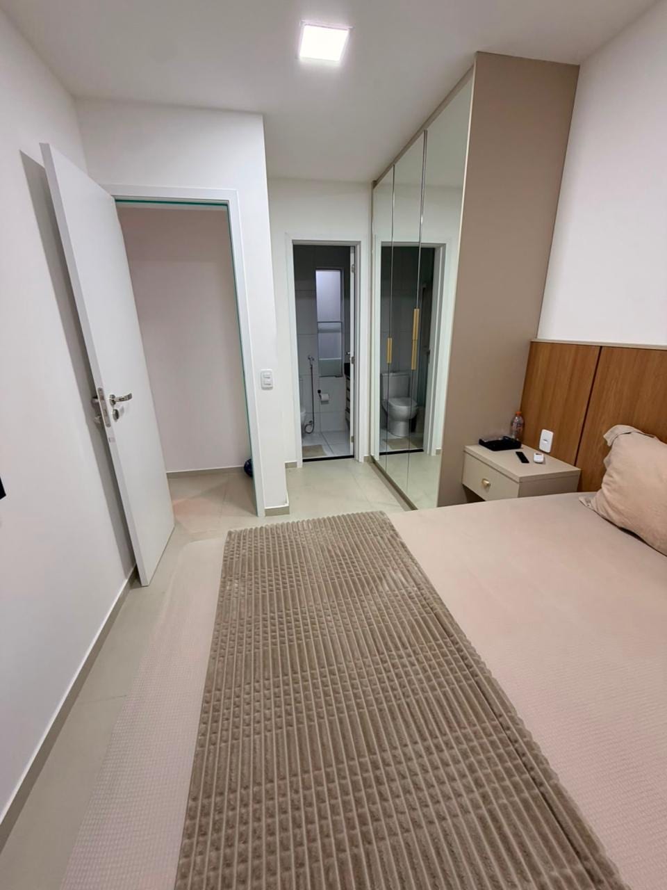 Quarto mobiliado com armário planejado espelhado
